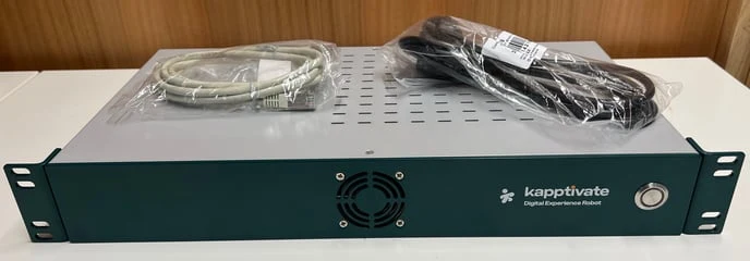 A green Kapptivate robot seen from the front, its power and network cables resting on top