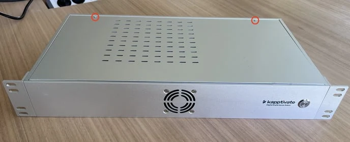 The top of a gray robot, its two lid screws circled in red