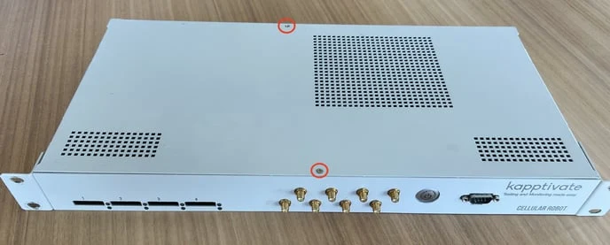 The top of a white robot, its two lid screws circled in red